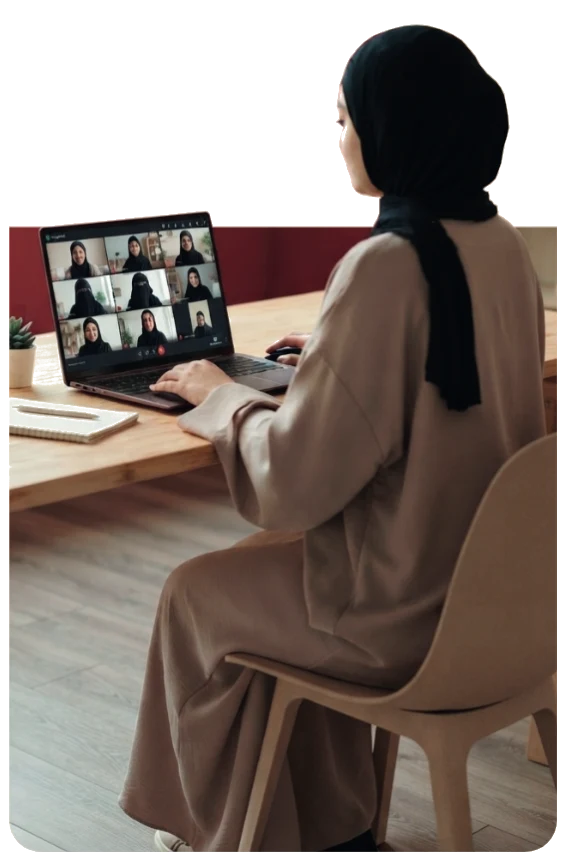 Apprenante voilée suivant un cours d’arabe en ligne sur ordinateur - Ayacademia